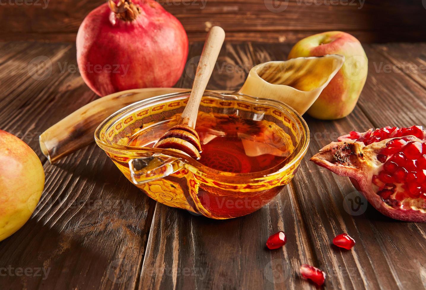 Rosh hashanah - jewish new year holiday concept. Bowl in the shape of an apple with honey, apples, pomegranates, shofar on wooden vintage background photo