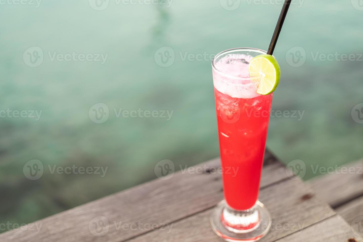 Summer Vacation Concept Fruit cocktail glass. Welcome drink put on wooden table nearly the sea. photo