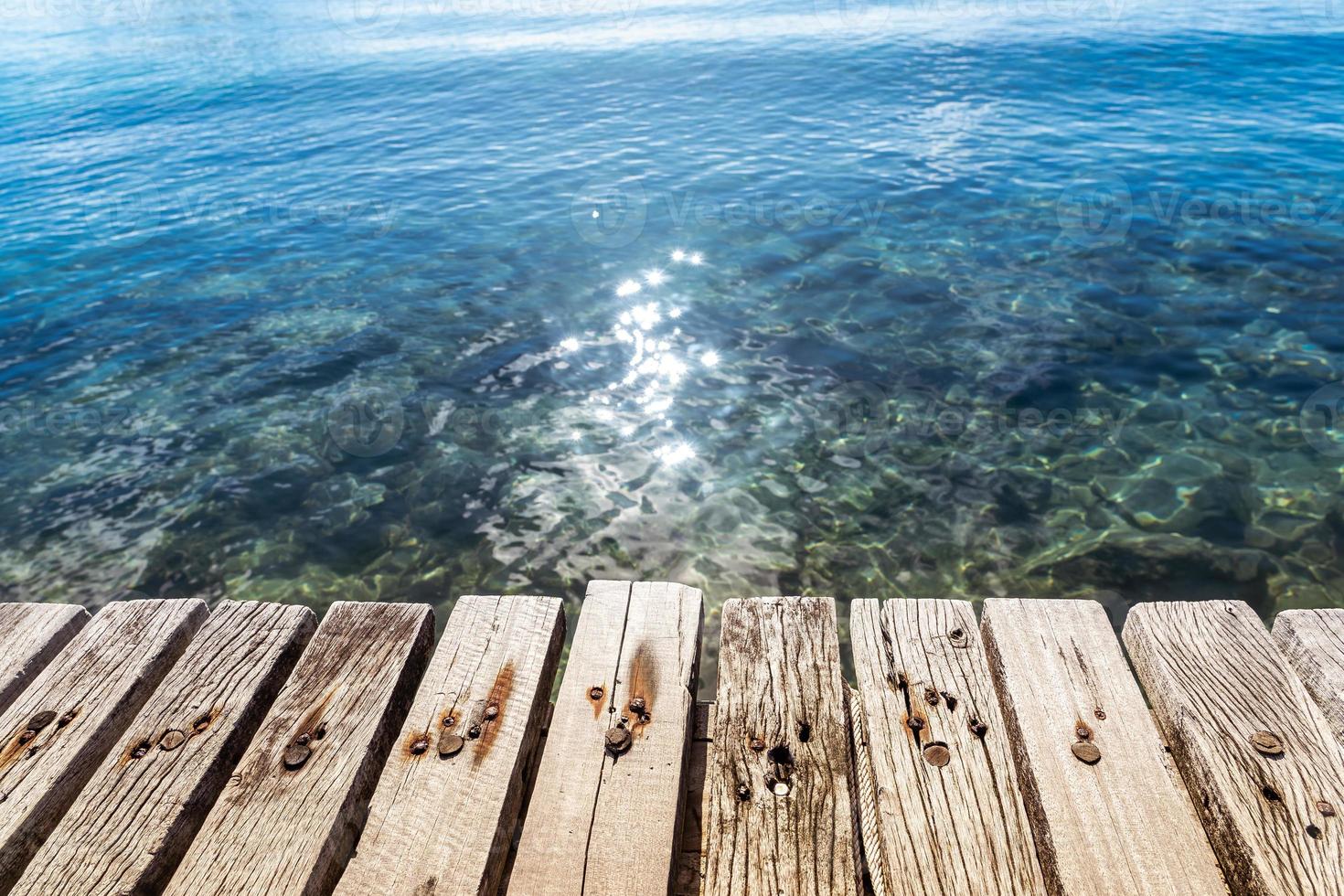 The wood floor extends into the sea. space for product or object presentation photo