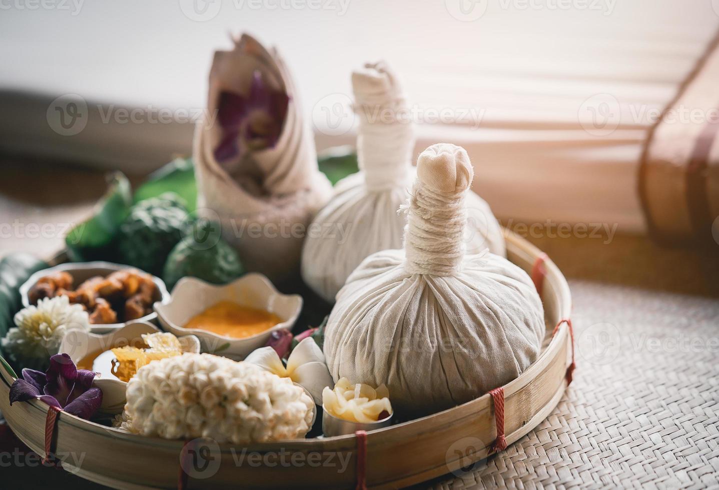 Spa massage wellness decorations setting on wood table. Thai spa massage traditional compress for hot massage and spa relaxing treatment of office syndrome. Massage for health concept. photo