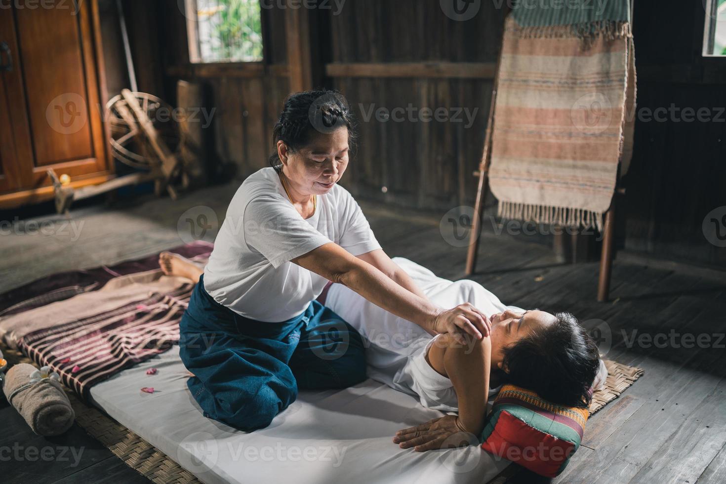 Massage and spa relaxing treatment of office syndrome traditional thai massage style. Asain senior female masseuse doing massage treat hand, back pain, arm pain, foot and stress for old woman tired. photo