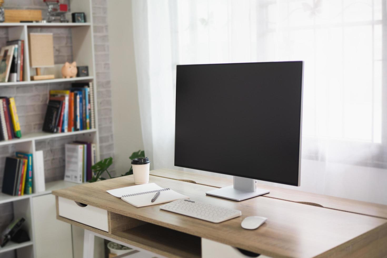 Close up view of worktable with laptop or computer, tablet, notebook and pen in home office room. Work at home place in the living room concept. photo
