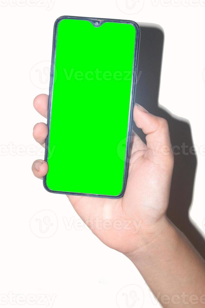 mano masculina sosteniendo un teléfono móvil en un fondo blanco adecuado para una pantalla verde, una mano sosteniendo un teléfono móvil de pantalla verde foto