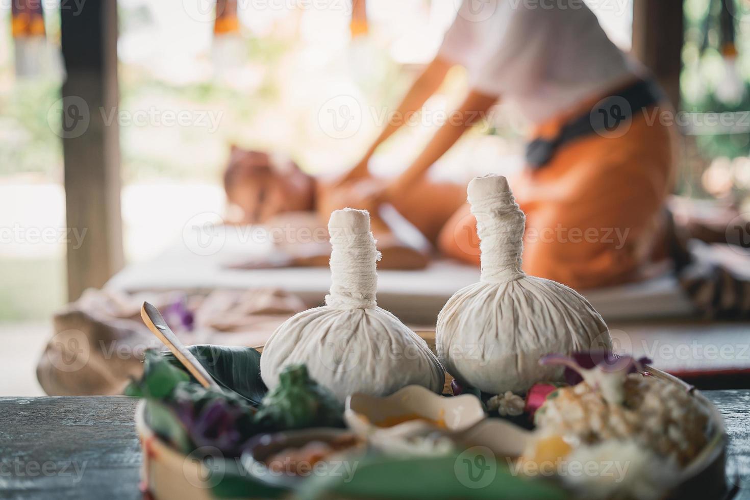 Spa massage wellness decorations setting on wood table. Thai spa massage traditional compress for hot massage and spa relaxing treatment of office syndrome. Massage for health concept. photo