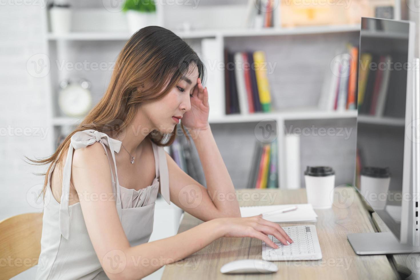 Asian business woman having stressful depression sad time working on laptop or computer on wood table at home office. Depression man sad serios working from anywhere. photo