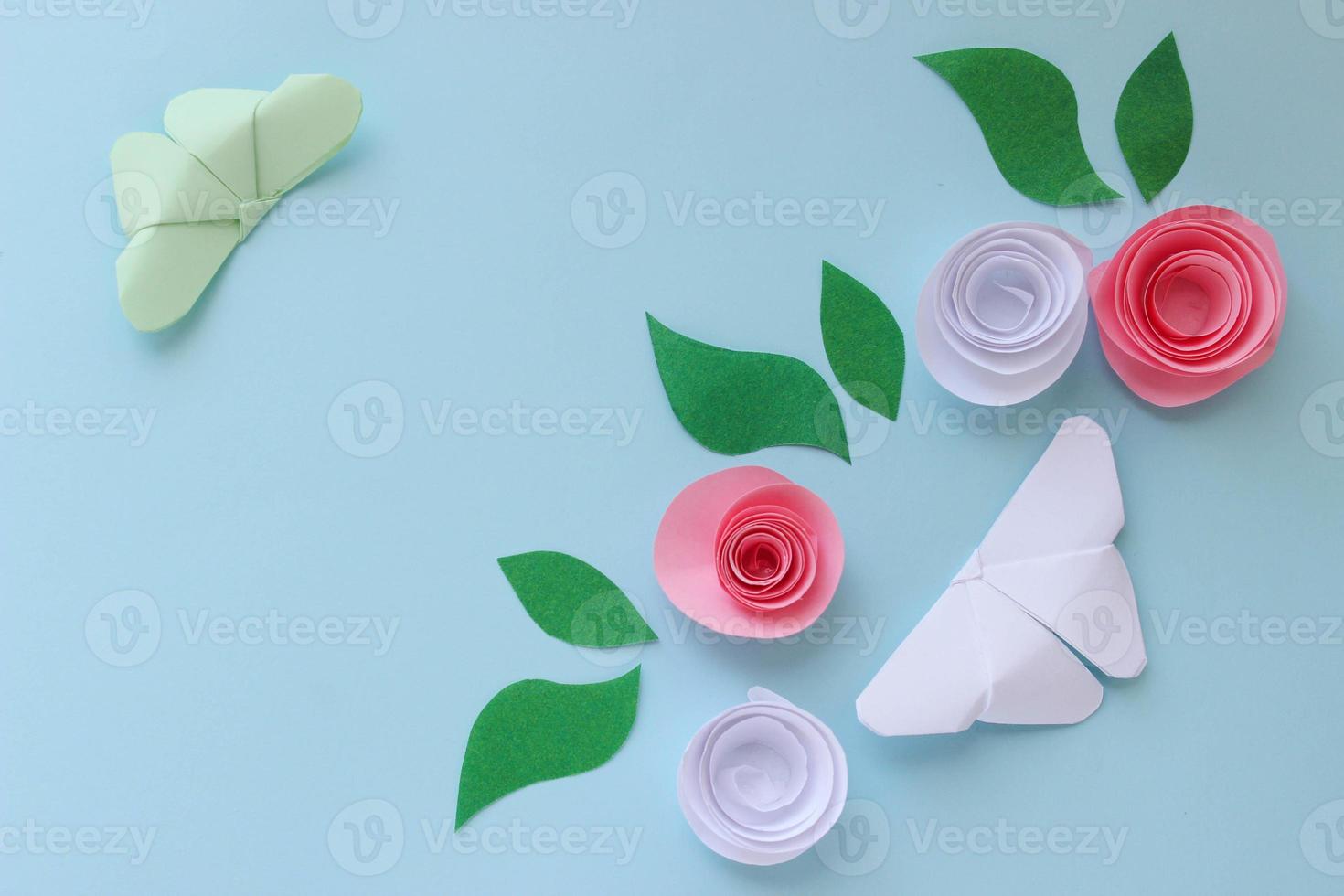 Origami paper background with two butterflies, flowers and leaves. With place for text. Origami composition. Paper craft photo