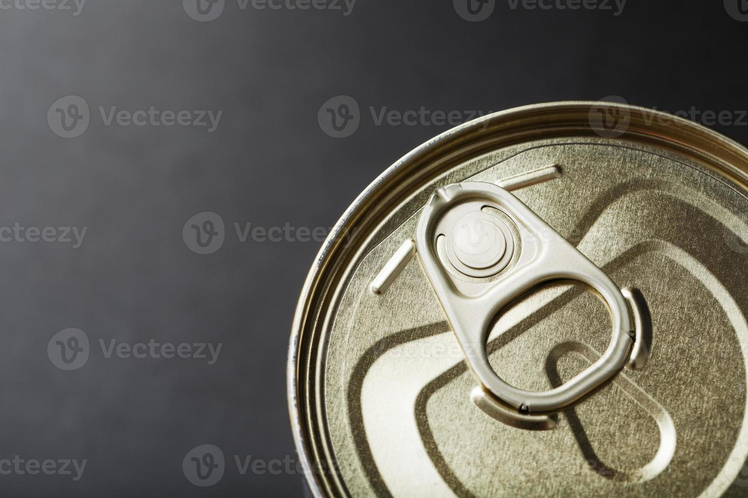 The lid of a metal tin can on a black background photo