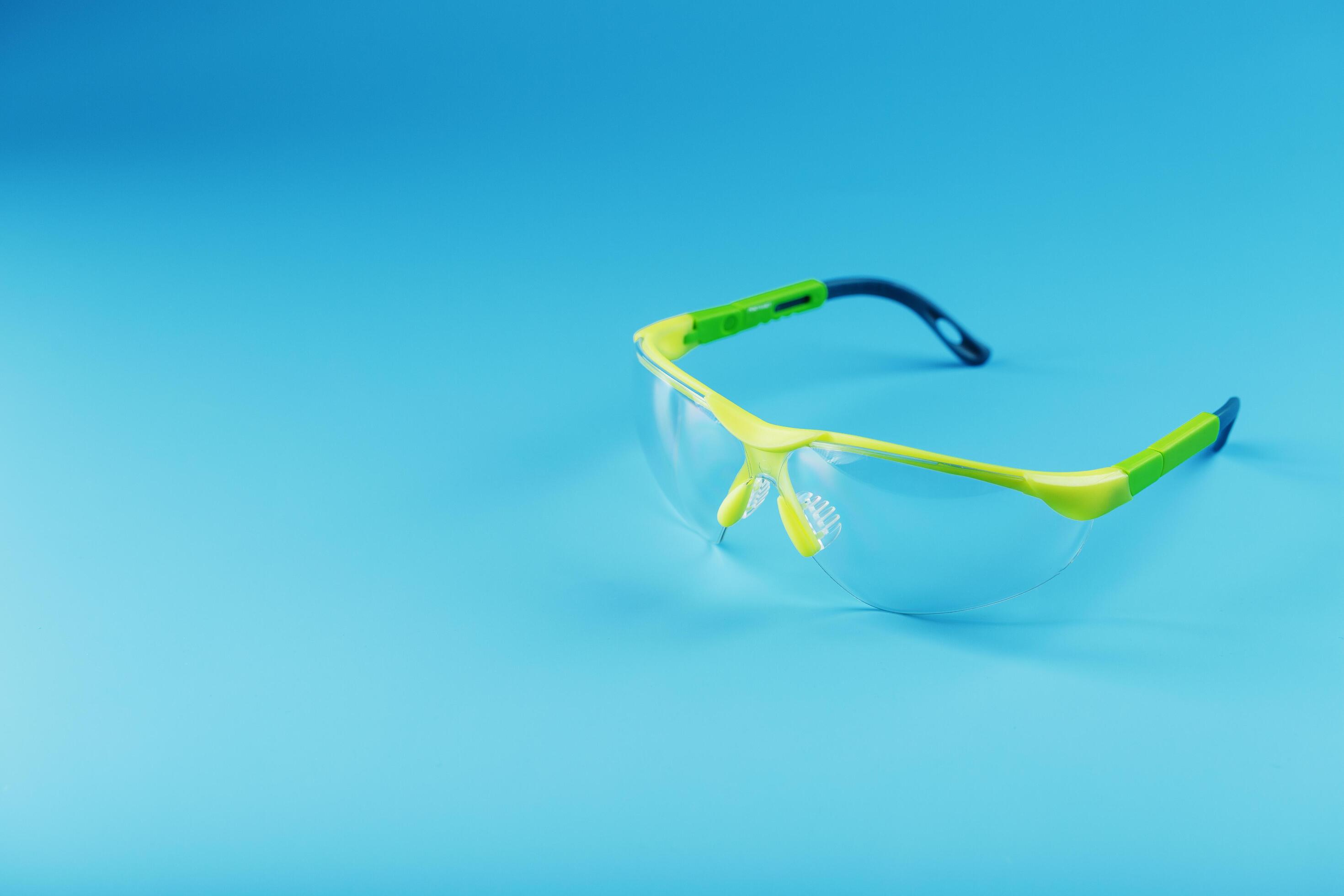 Transparent polycarbonate safety glasses on a blue background. 11069834
