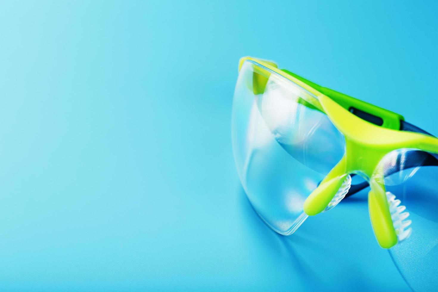 gafas de seguridad de policarbonato transparente sobre fondo azul. foto