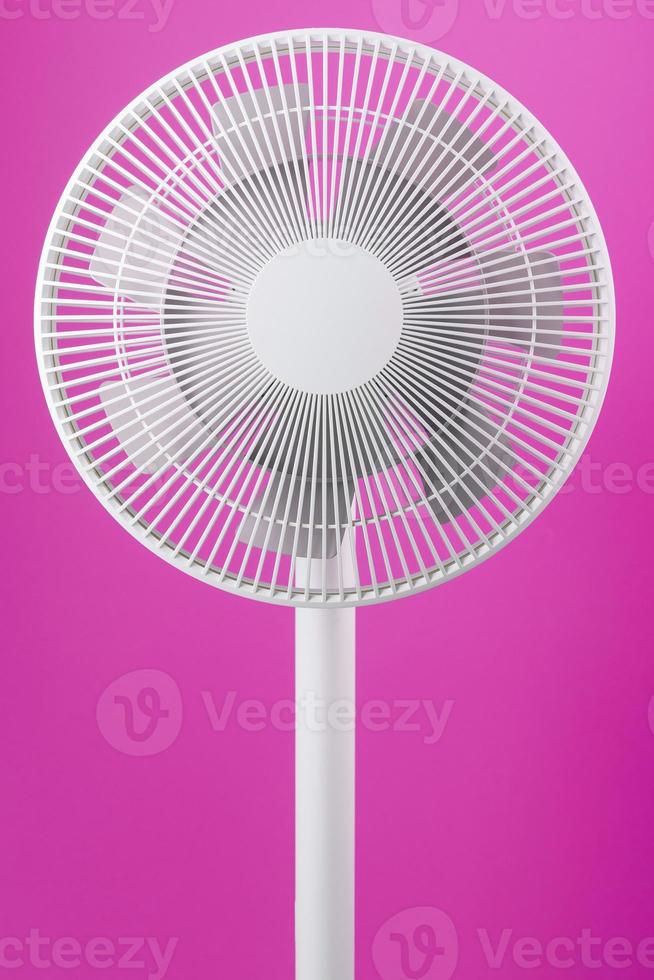 ventilador eléctrico en blanco con un diseño moderno para refrescar la habitación sobre un fondo rosa. foto