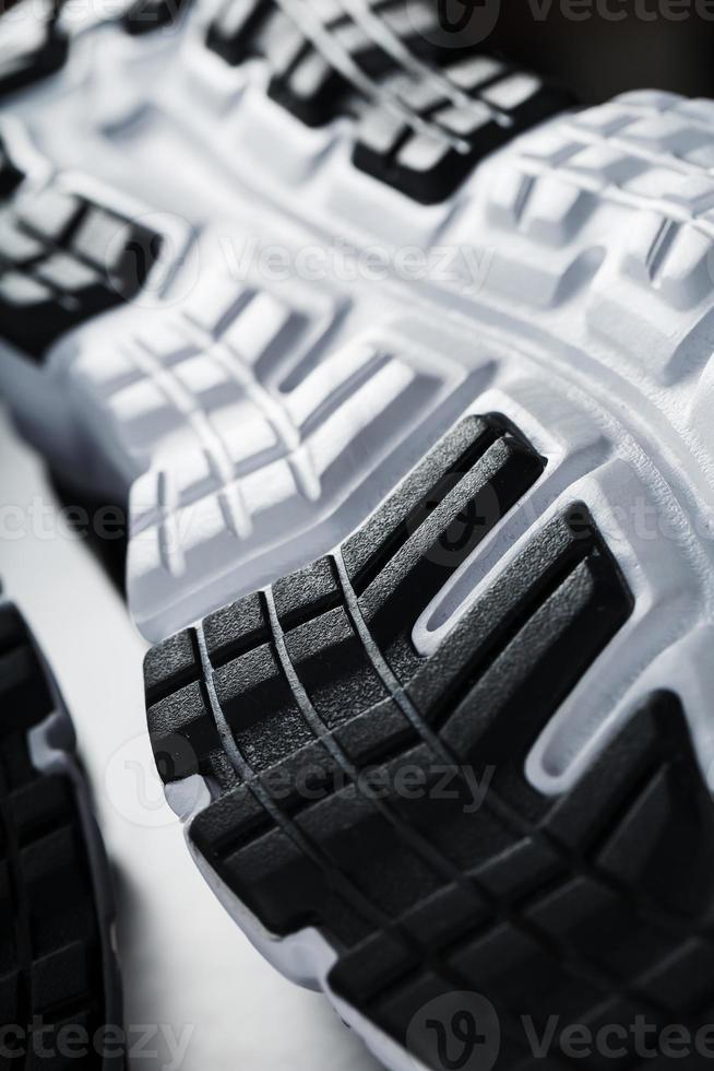 The black and white sole of trendy sports sneakers is a close-up in full screen. photo