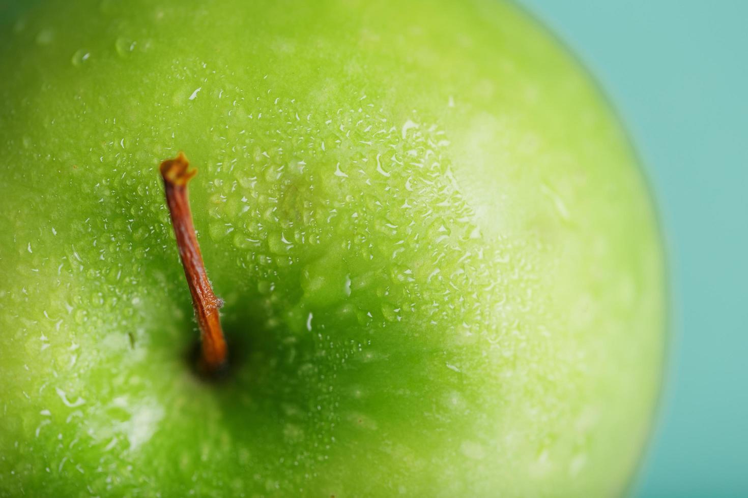 una manzana verde sobre un fondo verde con una composición minimalista. foto