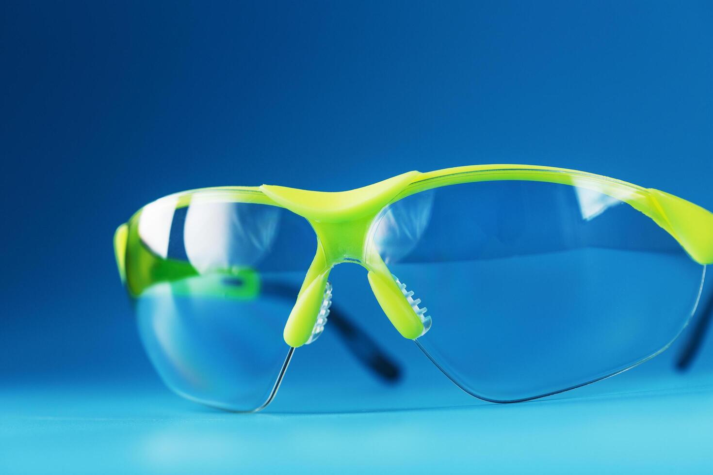 gafas verdes protectoras tecnológicas aisladas en un fondo azul. foto