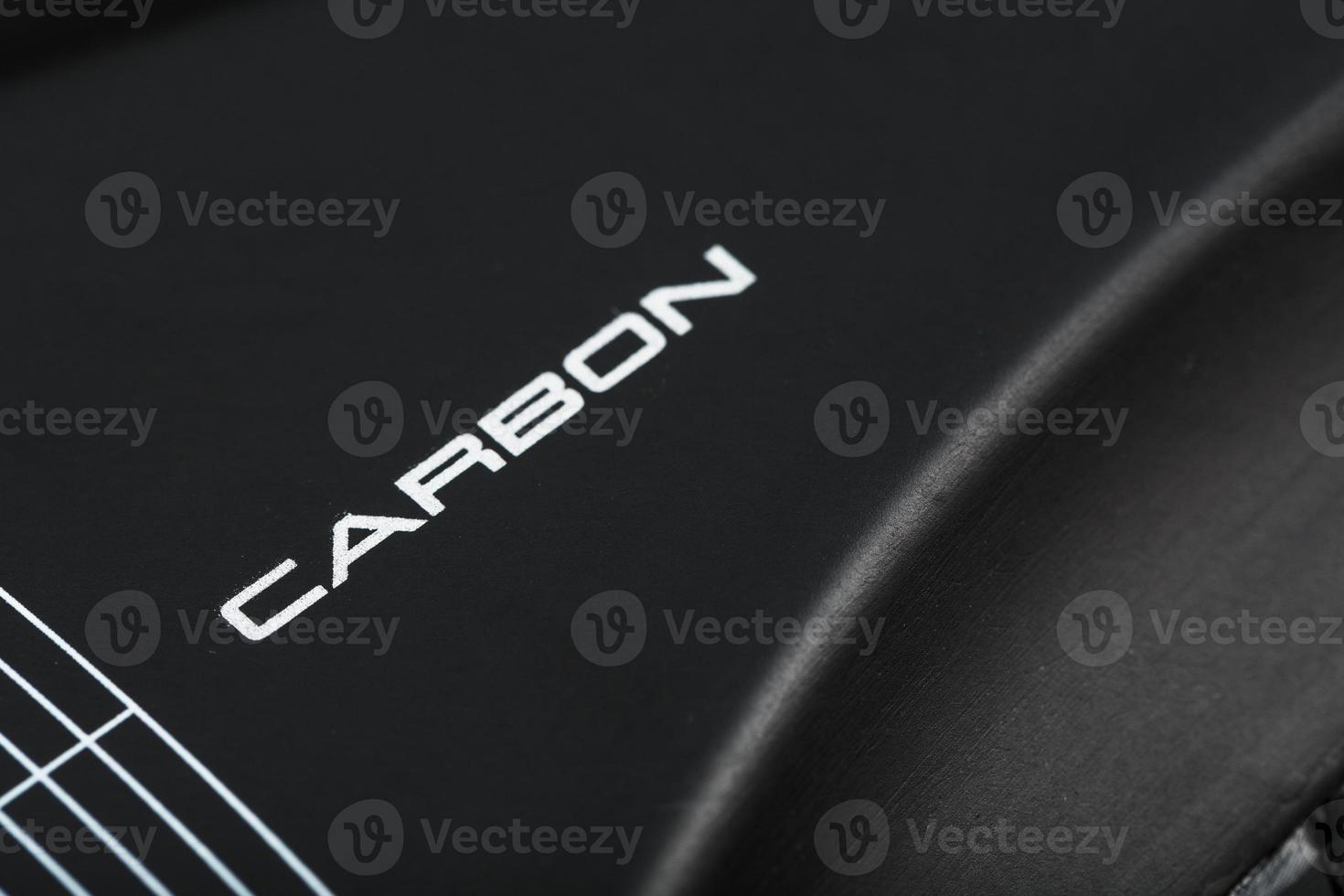 Carbon element of cycling shoes with the inscription CARBON on a black background close-up. photo