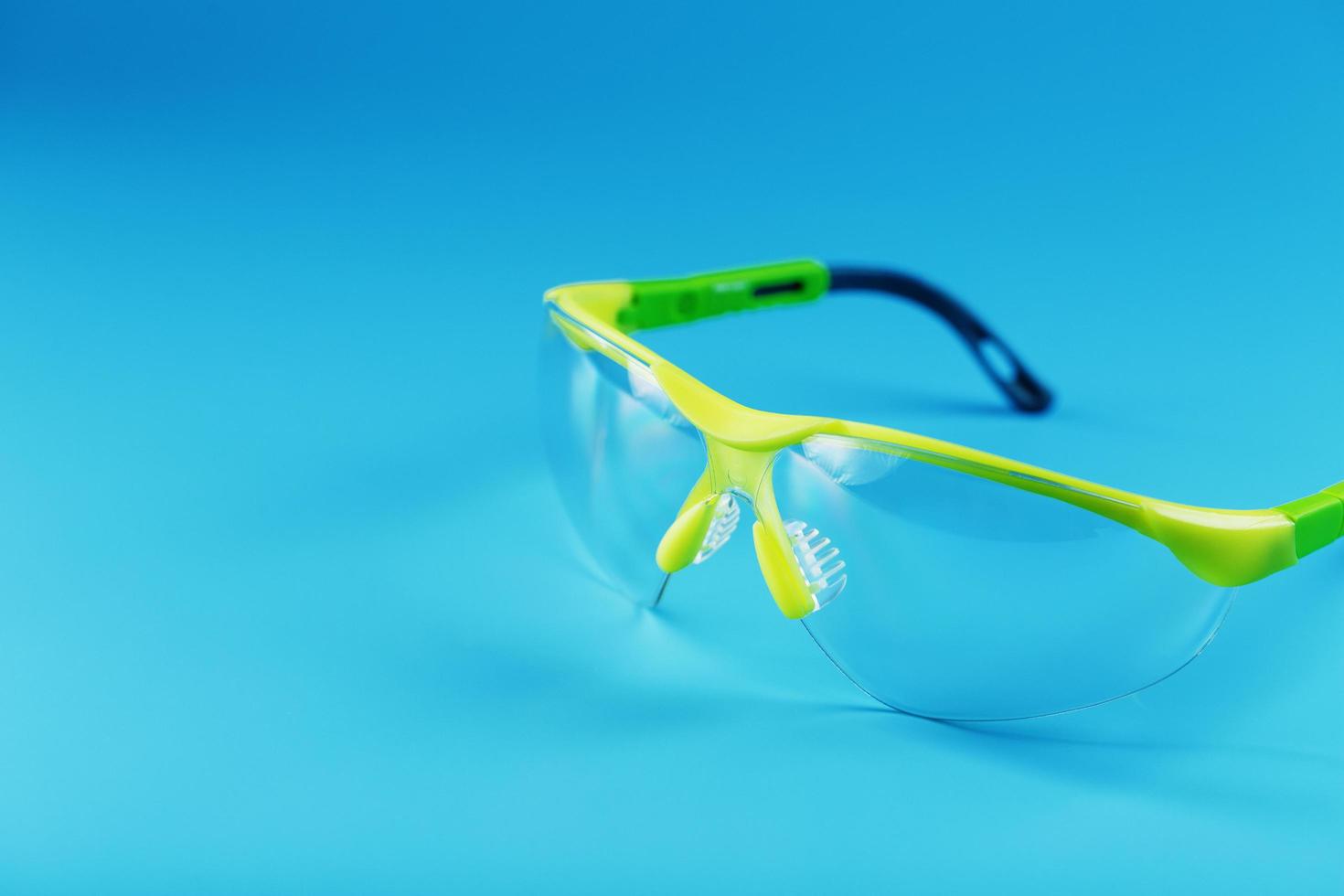gafas de seguridad de policarbonato transparente sobre fondo azul. foto