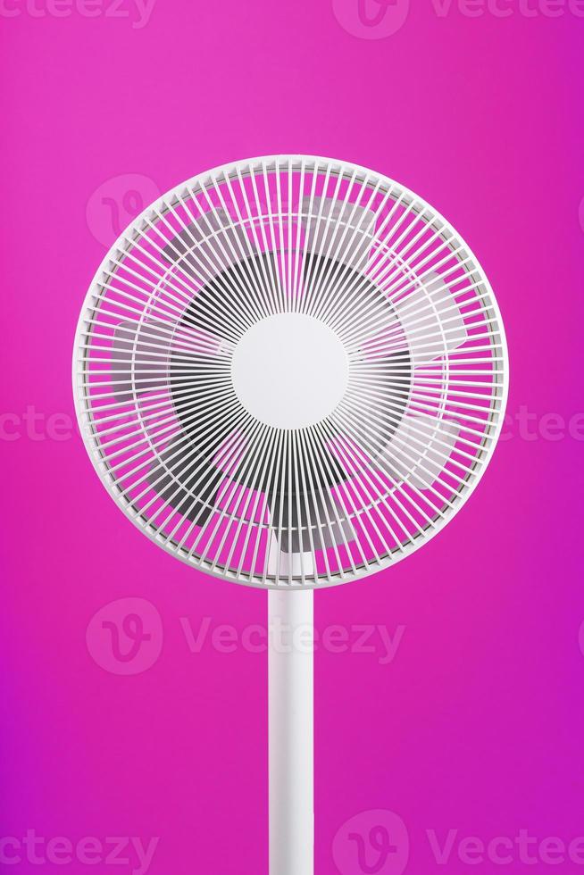 ventilador eléctrico en blanco con un diseño moderno para refrescar la habitación sobre un fondo rosa. foto