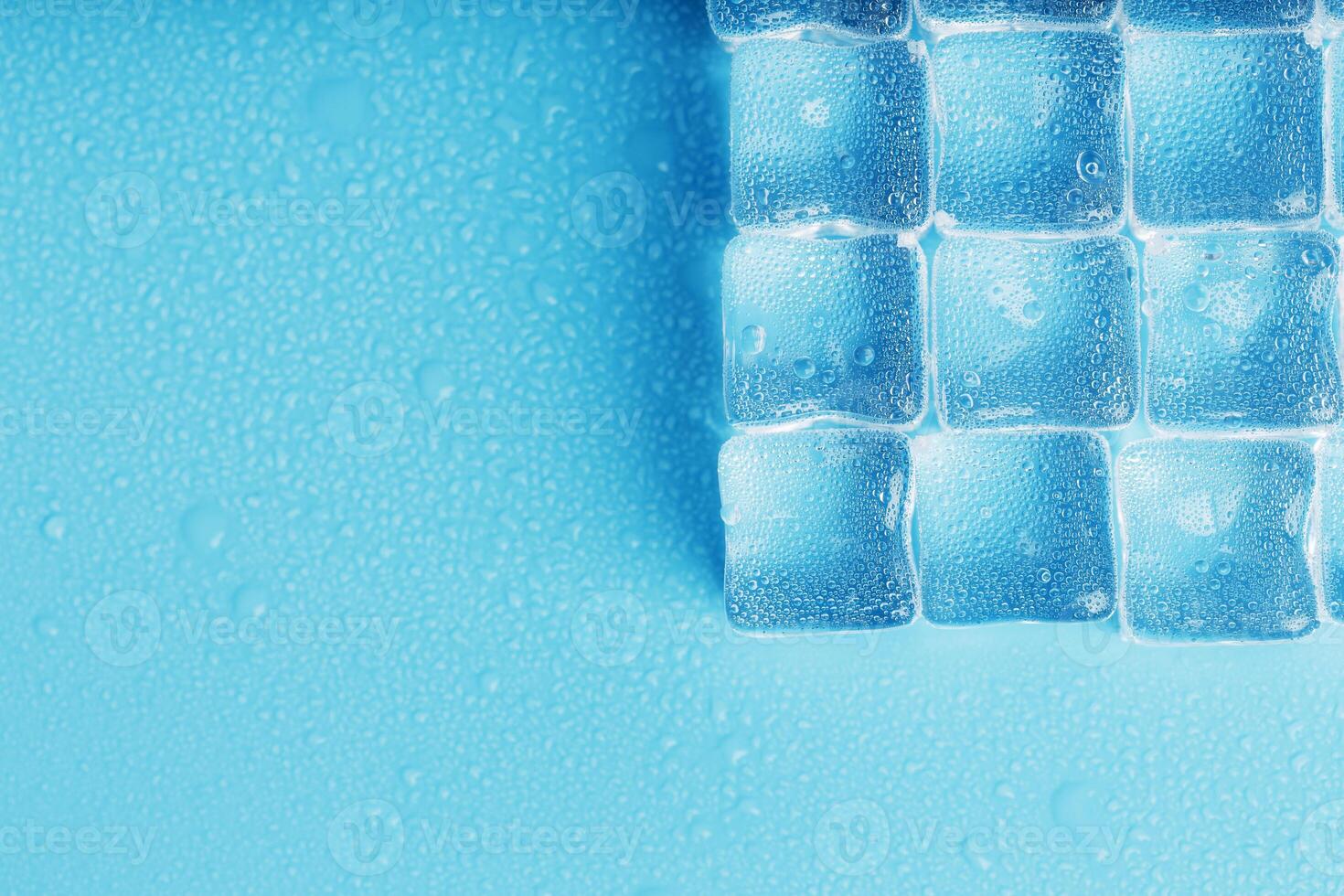 Ice made of cubes lined up with drops on a blue background 11070935