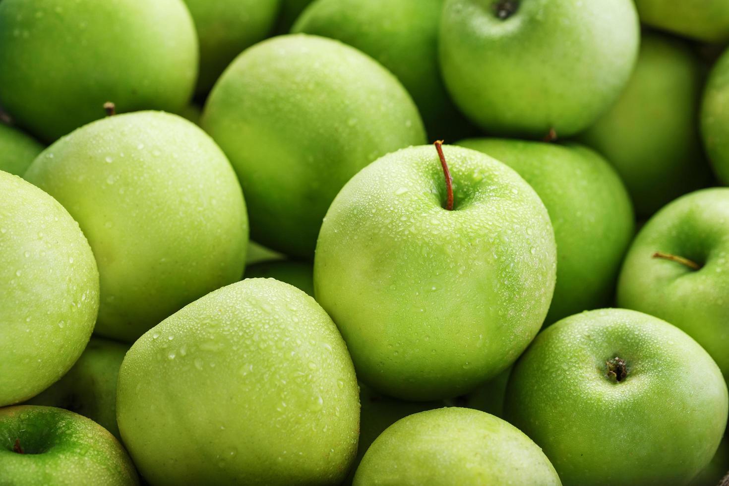 primer plano de jugosa manzana verde con gotas de rocío. foto