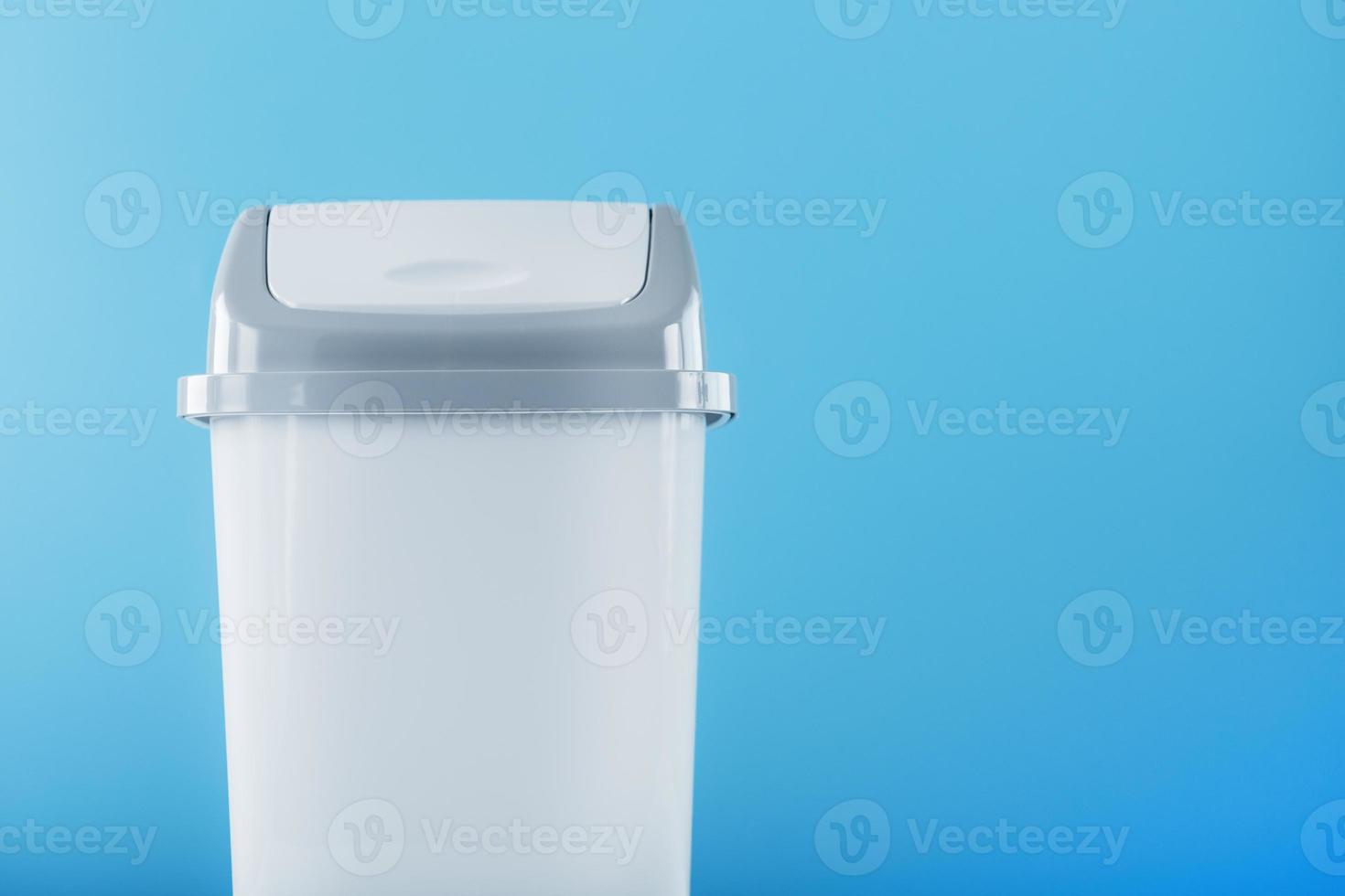 White trash can on a light blue background with free space. photo