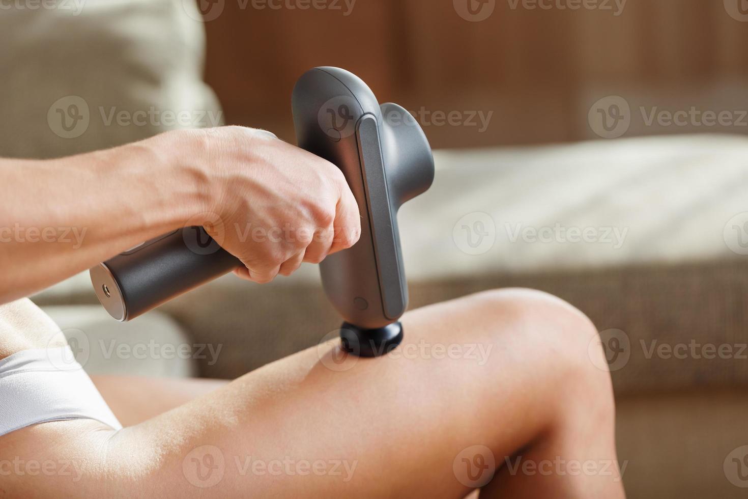 Massage of women's legs with a shock massage device. photo