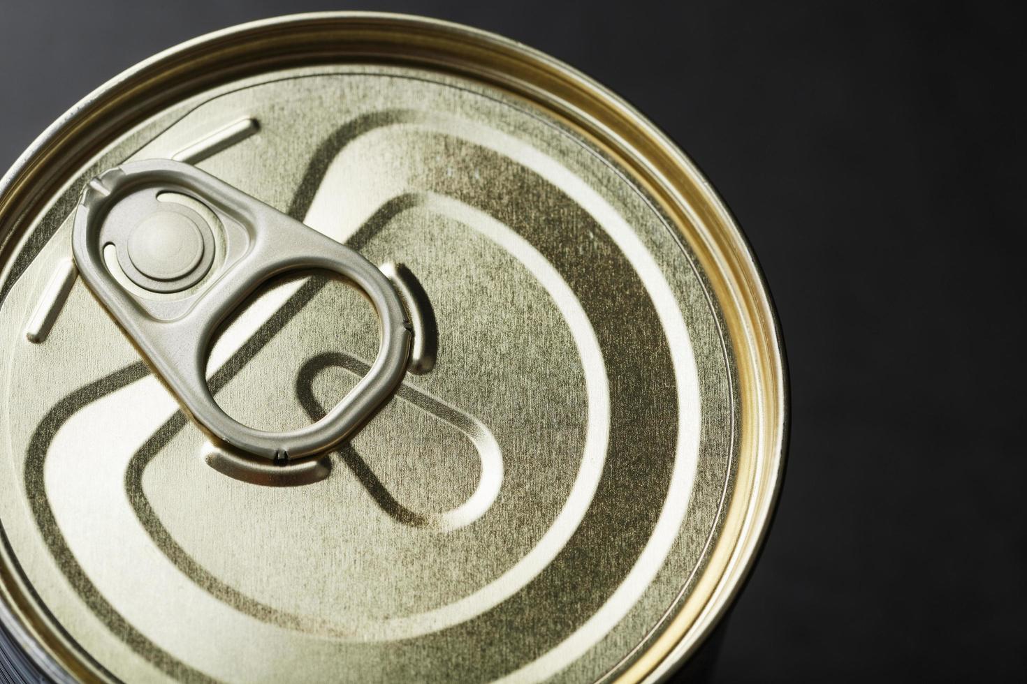 The lid of a metal tin can on a black background photo