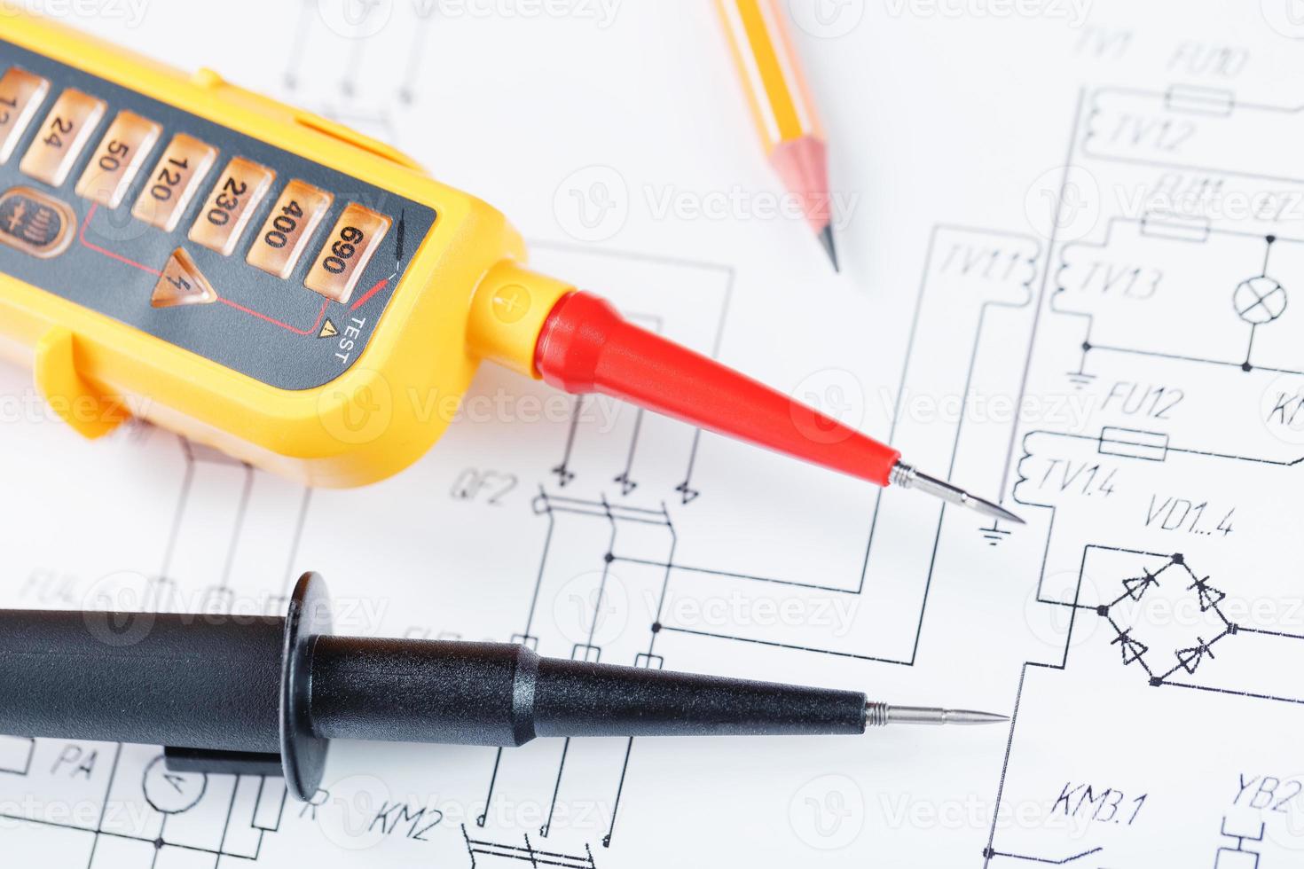 The two-pole voltage indicator lies on the electrical drawing. photo