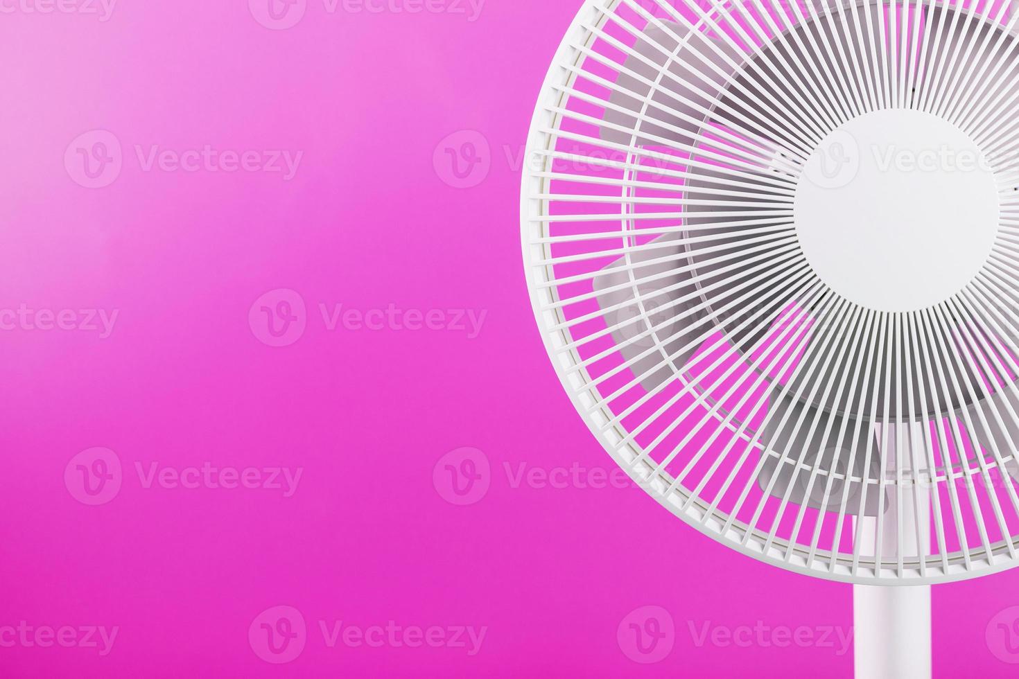 ventilador eléctrico en blanco con un diseño moderno para refrescar la habitación sobre un fondo rosa. foto