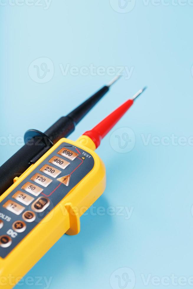 Yellow tester for step-by-step indication of voltage in an electrical circuit on a blue background photo