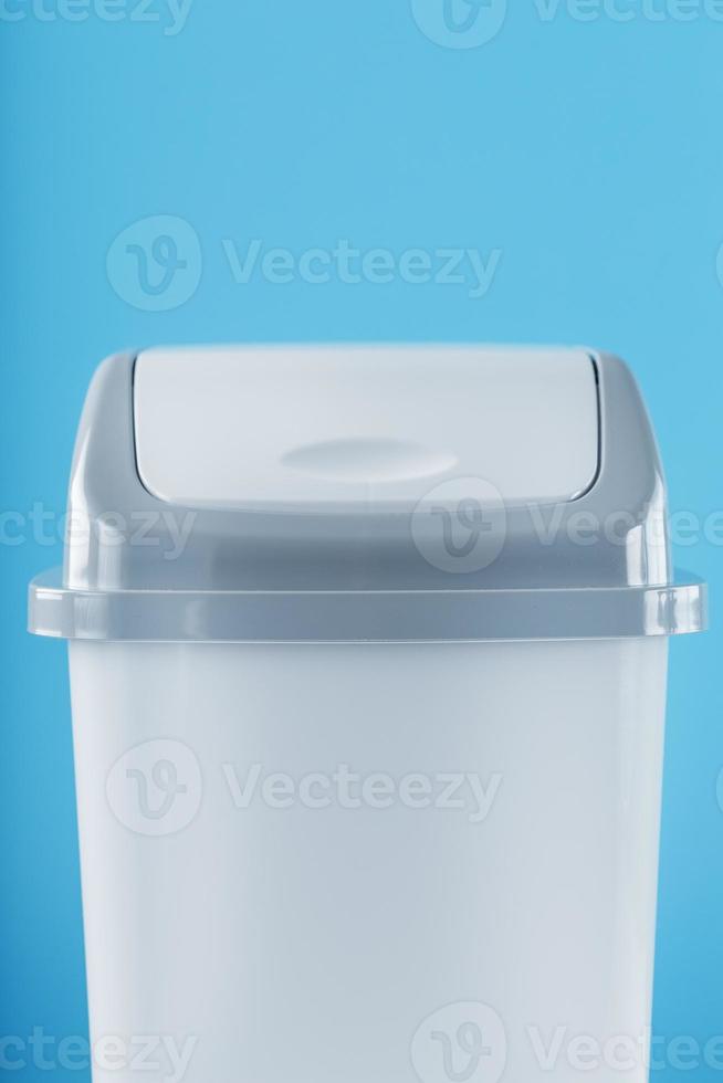 White trash can on a light blue background with free space. photo