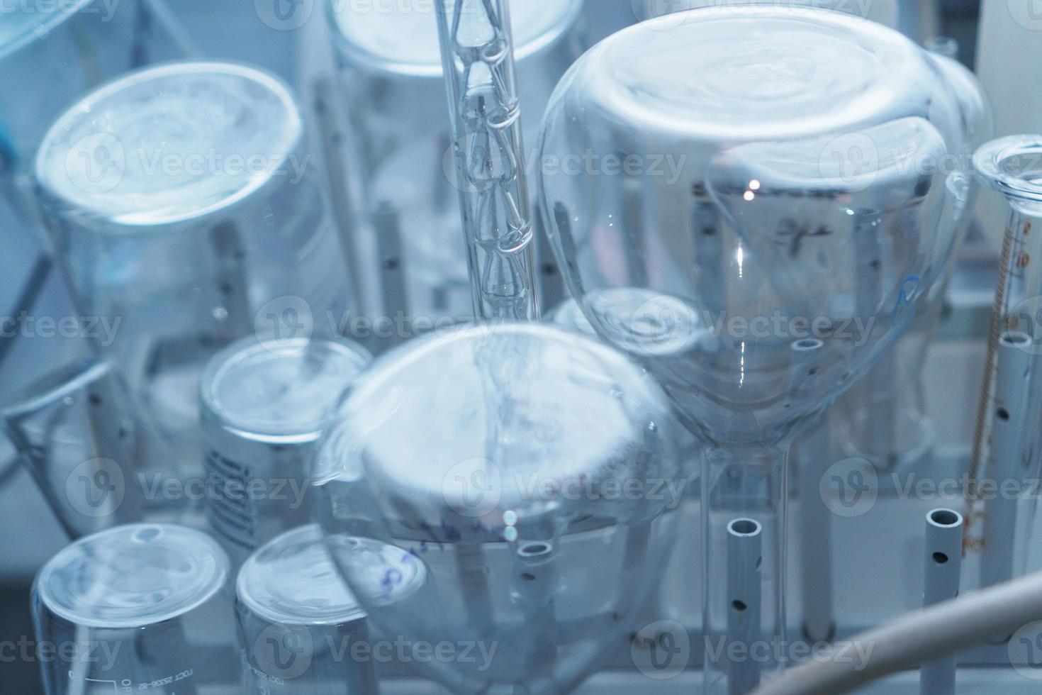 frascos de vidrio de laboratorio y tubos de ensayo en un estante. foto