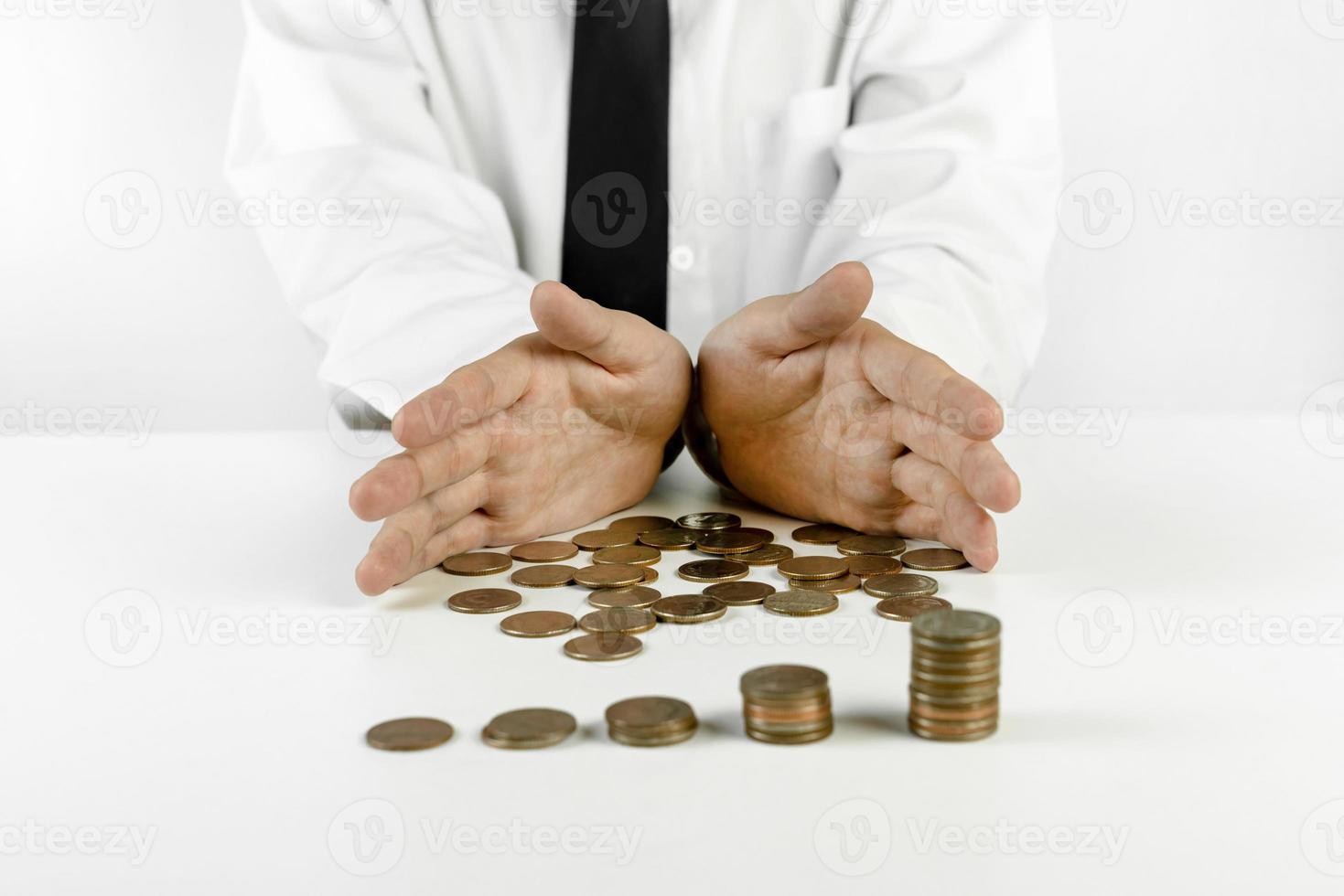empresario manos protegiendo pilas de monedas sobre fondo blanco foto