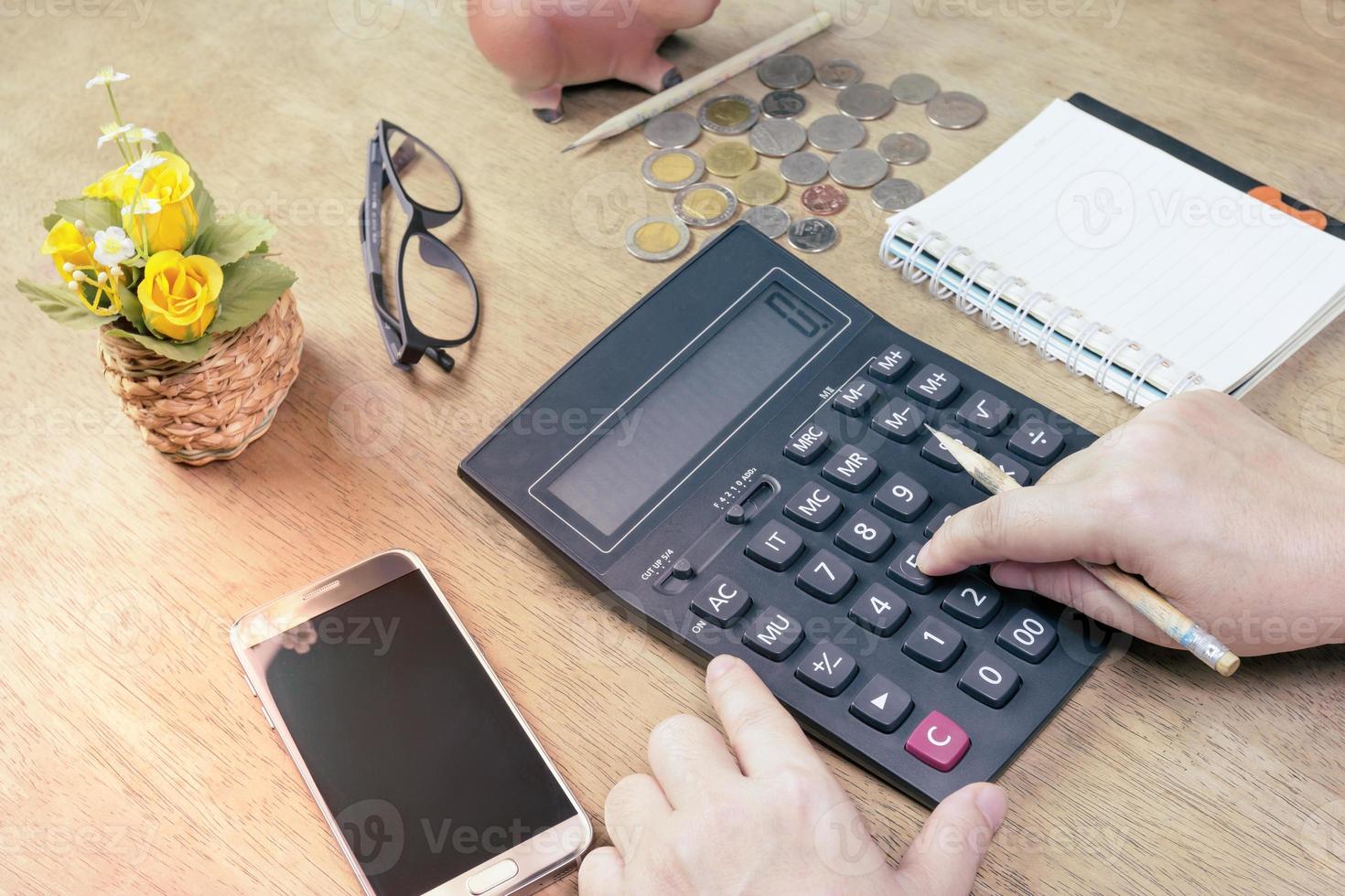 Woman using calculator with notepad on desk,business concept photo