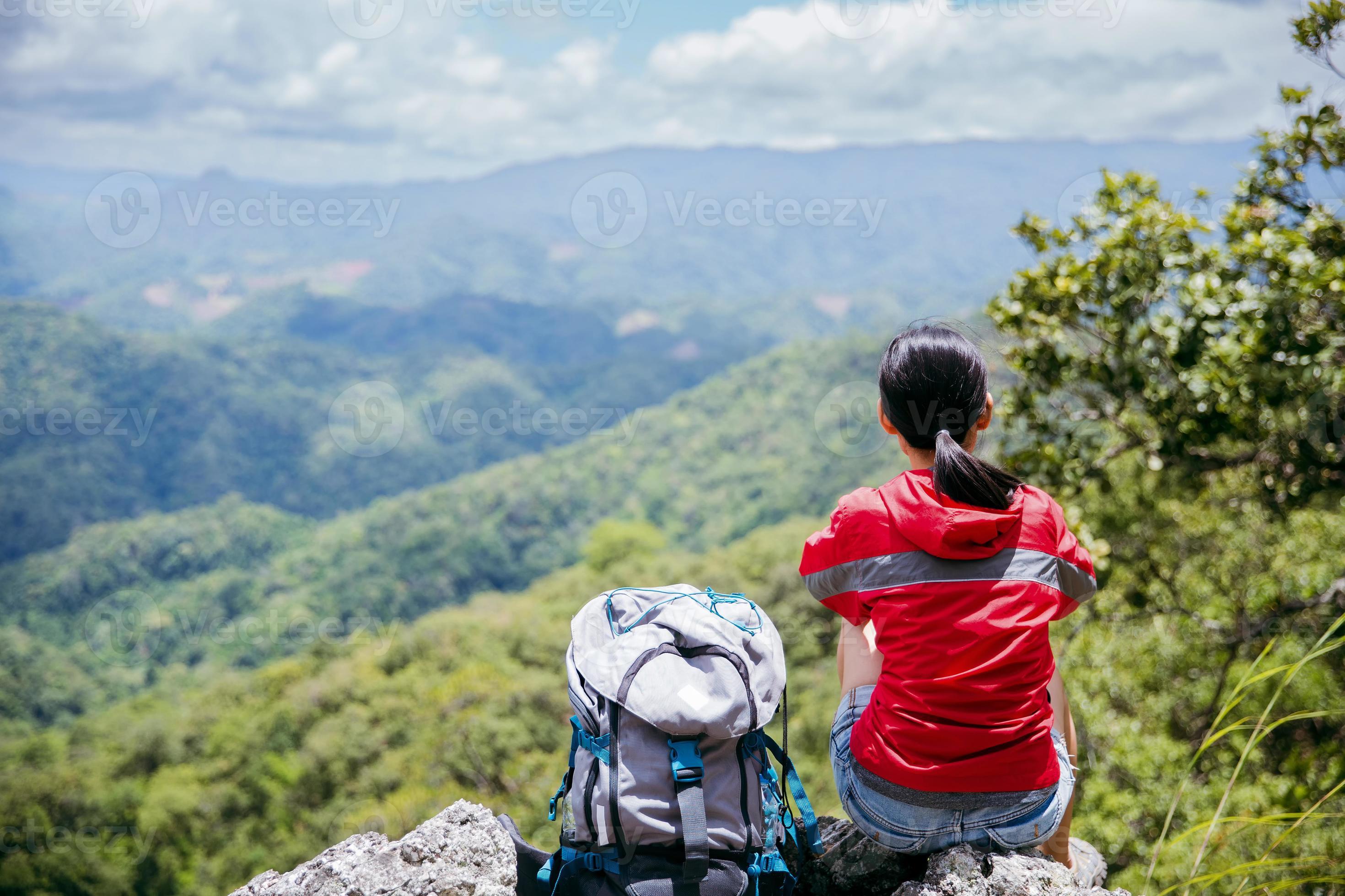 Deporte De Senderismo O Trekking Mujer Con Chaqueta De Color Púrpura,  Sentado En El Pico De La Roca, Escribiendo Teléfono Inteligente Móvil,  Detrás Del Valle De Lozoya Y El Parque Guadarrama, En