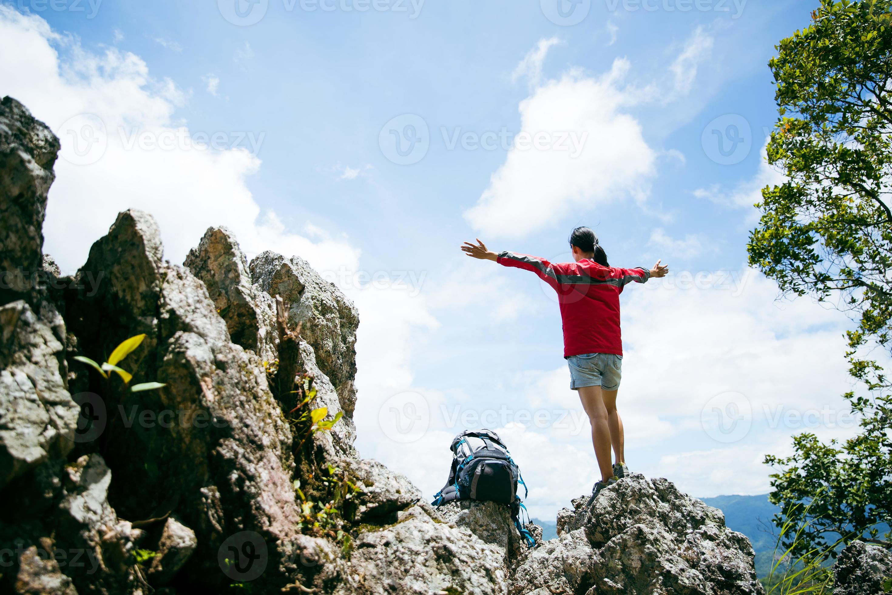 Young person hiking female standing on top rock, Backpack woman looking at  beautiful mountain valley at sunlight in summer, Landscape with sport girl,  high hills, forest, sky. Travel and tourism. 10266232 Stock
