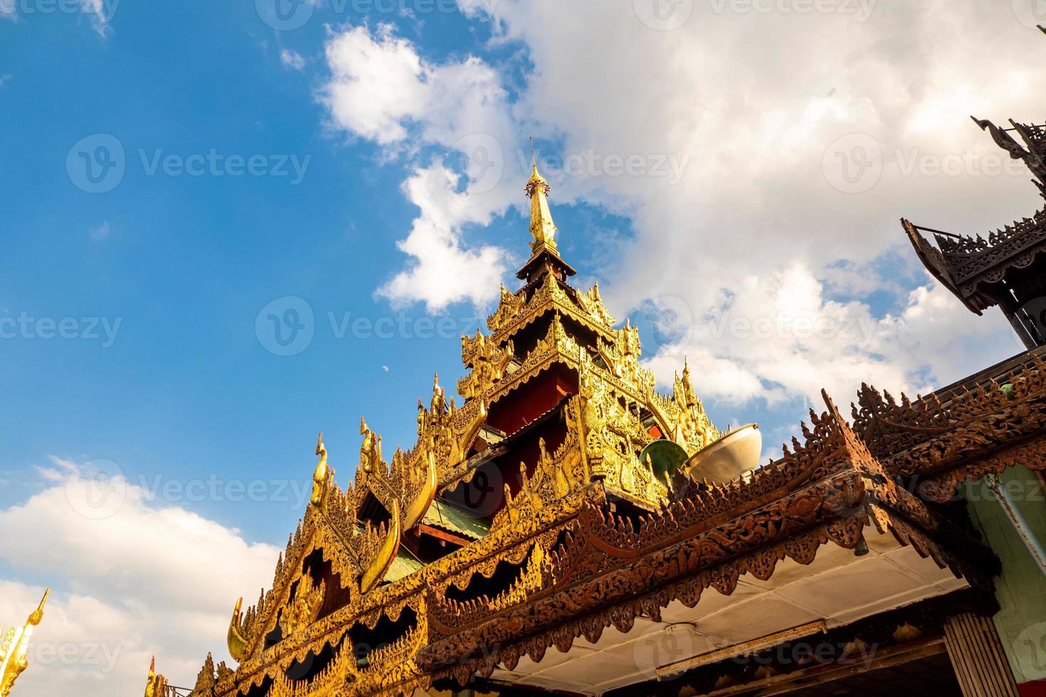 The castle mondop square hall with a pyramidal roof and the golden pagoda in the Burmese temple photo