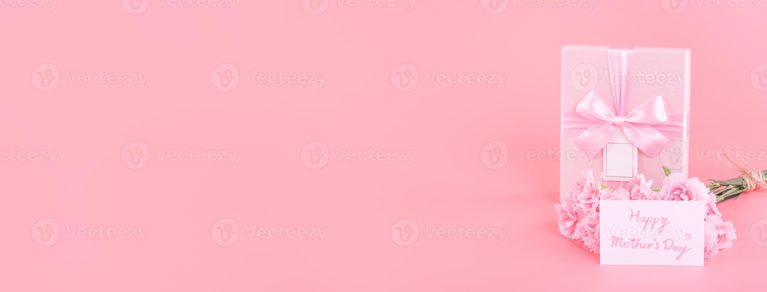 concepto de diseño de regalo de vacaciones del día de la madre, ramo de flores de clavel rosa con tarjeta de felicitación, aislado en fondo rosa claro, espacio de copia. foto