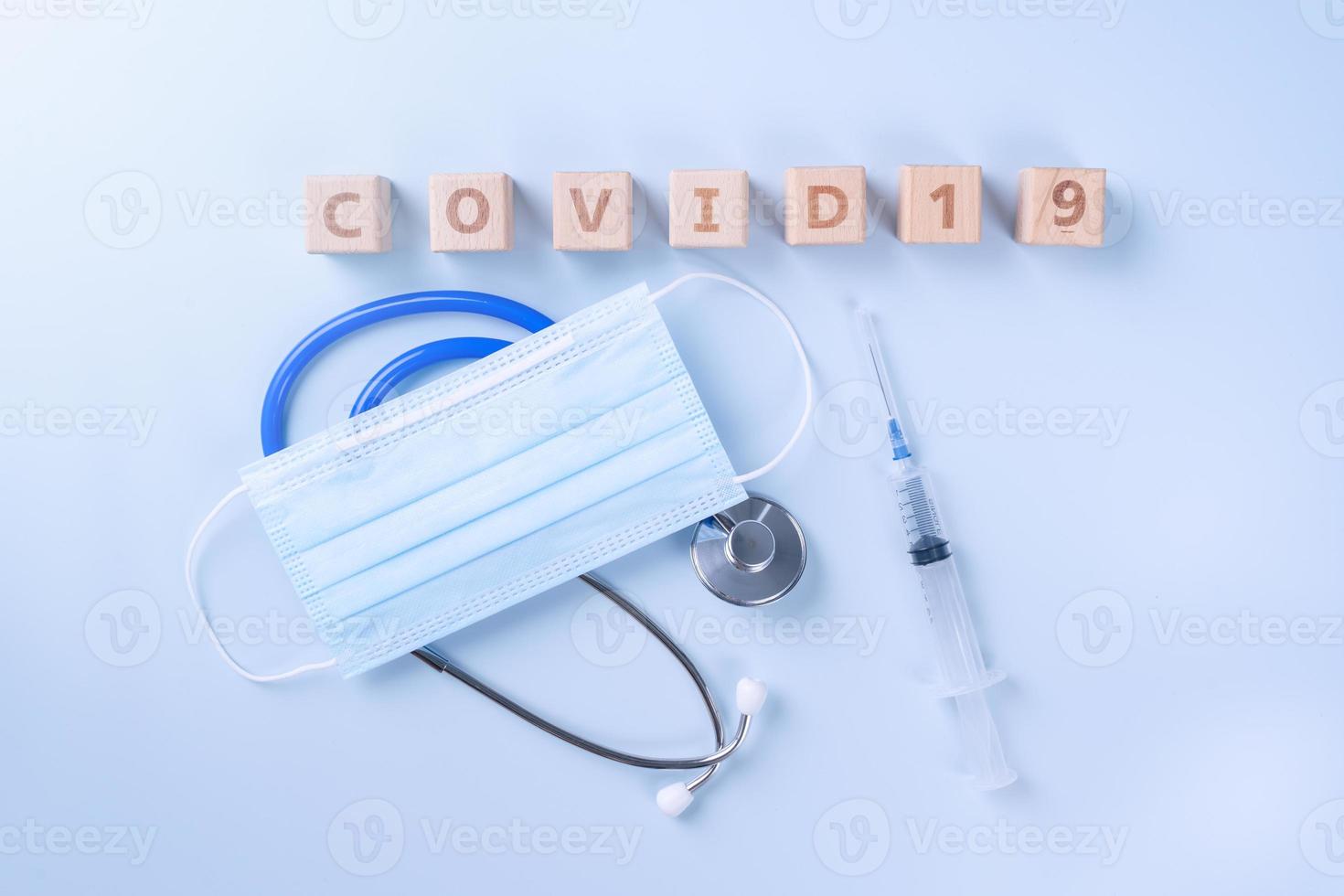 covid-19 palabra cubo de madera con máscara, equipo médico, concepto de prevención e infección pandémica de enfermedades mundiales, vista superior, plano, diseño superior foto