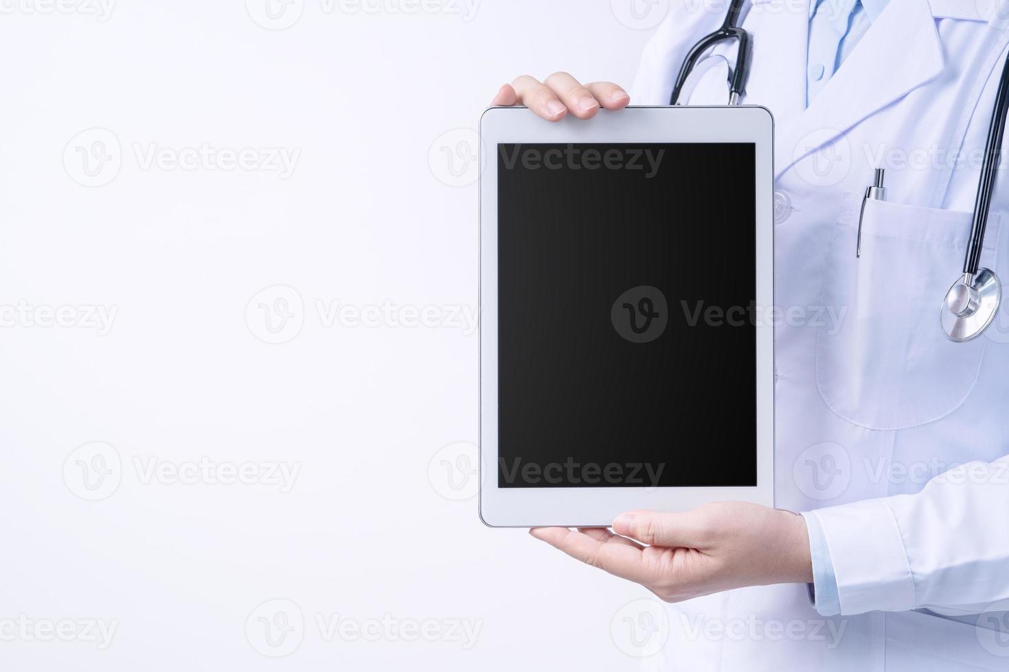 Doctor with stethoscope in white coat holding tablet, showing medical information, diagnosis, isolated on white background, close up, cropped view. photo