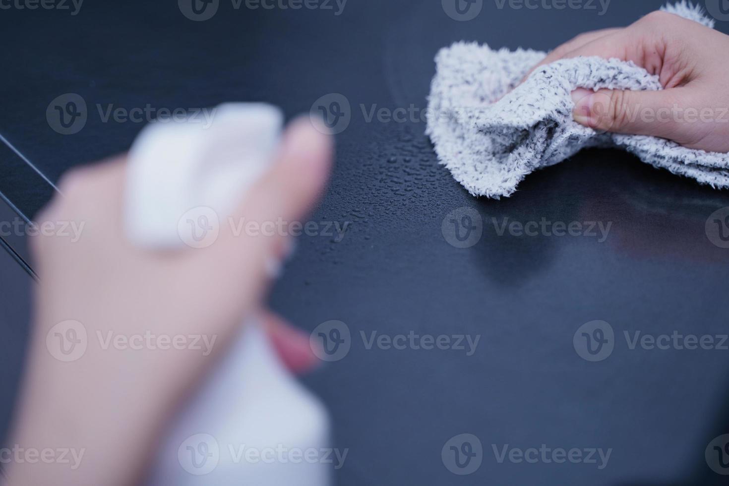 la mujer joven está sosteniendo una botella de spray, un trapo para limpiar, limpiar la superficie de alojamiento del estante del gabinete de metal de la oficina, cerrar, estilo de vida, concepto de antibacteriano. foto