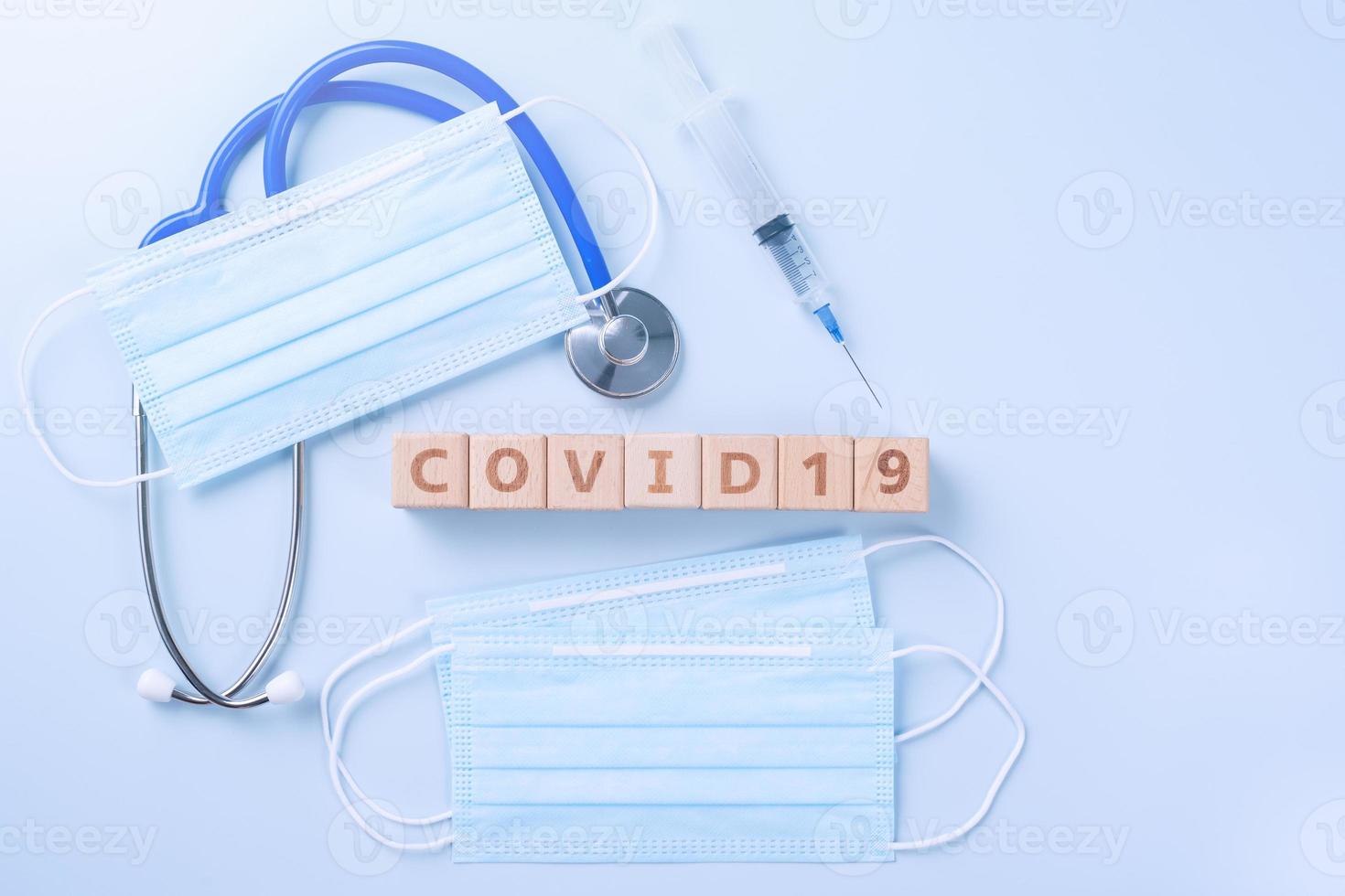 COVID-19 word wooden cube with mask, medical equipment, world disease pandemic infection and prevention concept, top view, flat lay, overhead design photo