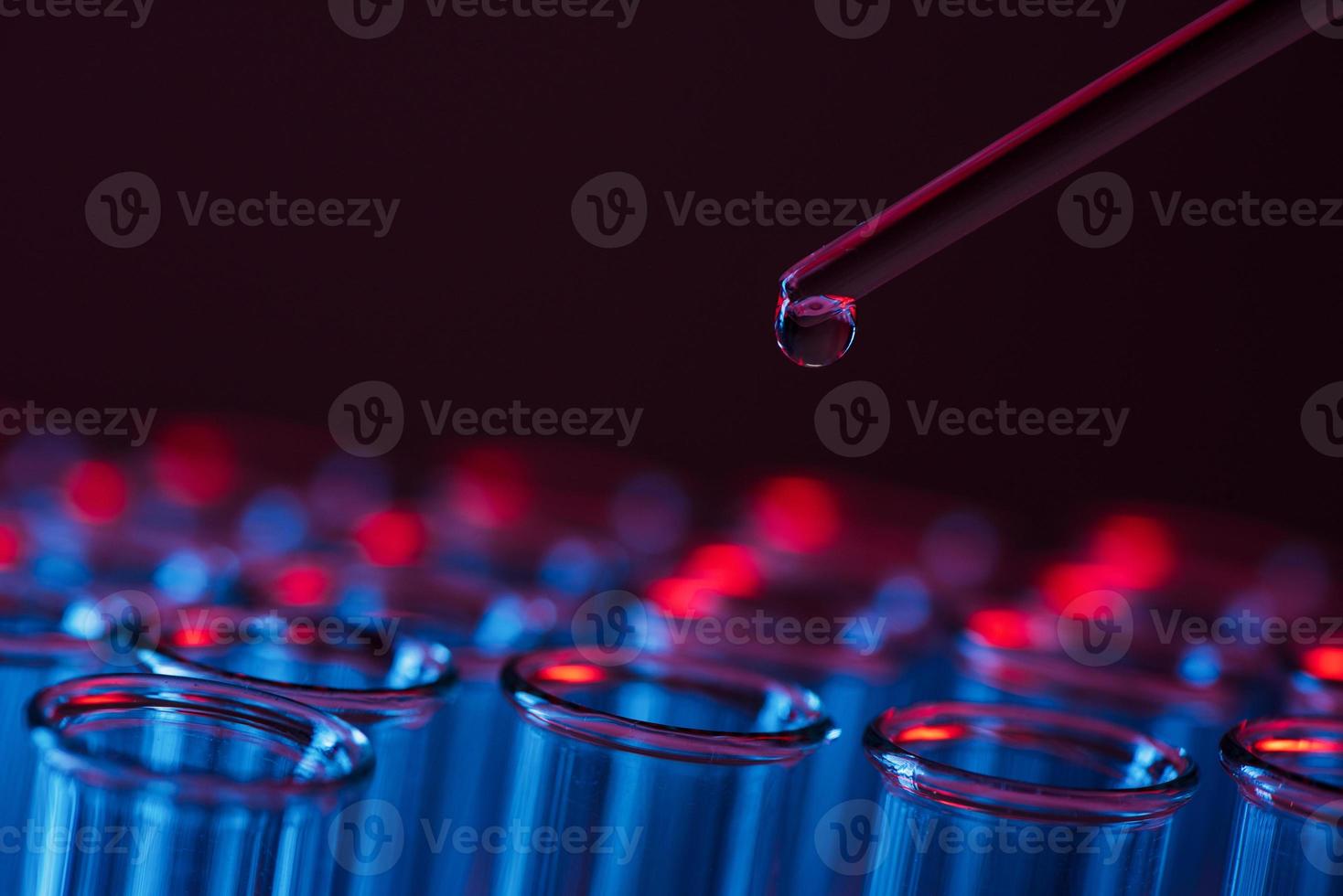 Test tube row. Concept of medical or science laboratory, liquid drop droplet with dropper in blue tone background, close up, micro photography picture. photo