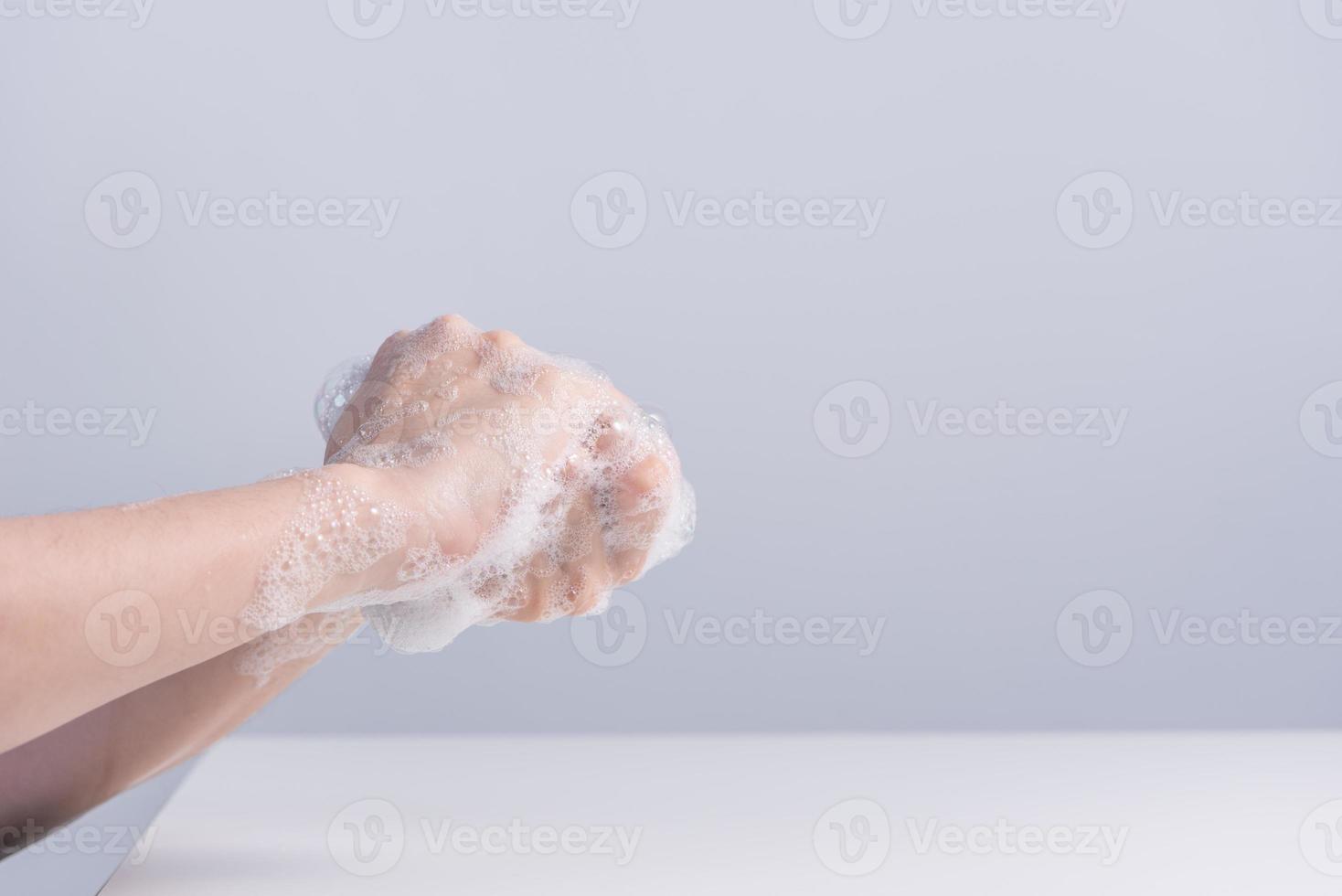 Washing hands. Asian young woman using liquid soap to wash hands, concept of hygiene to protective pandemic coronavirus isolated on gray white background, close up. photo