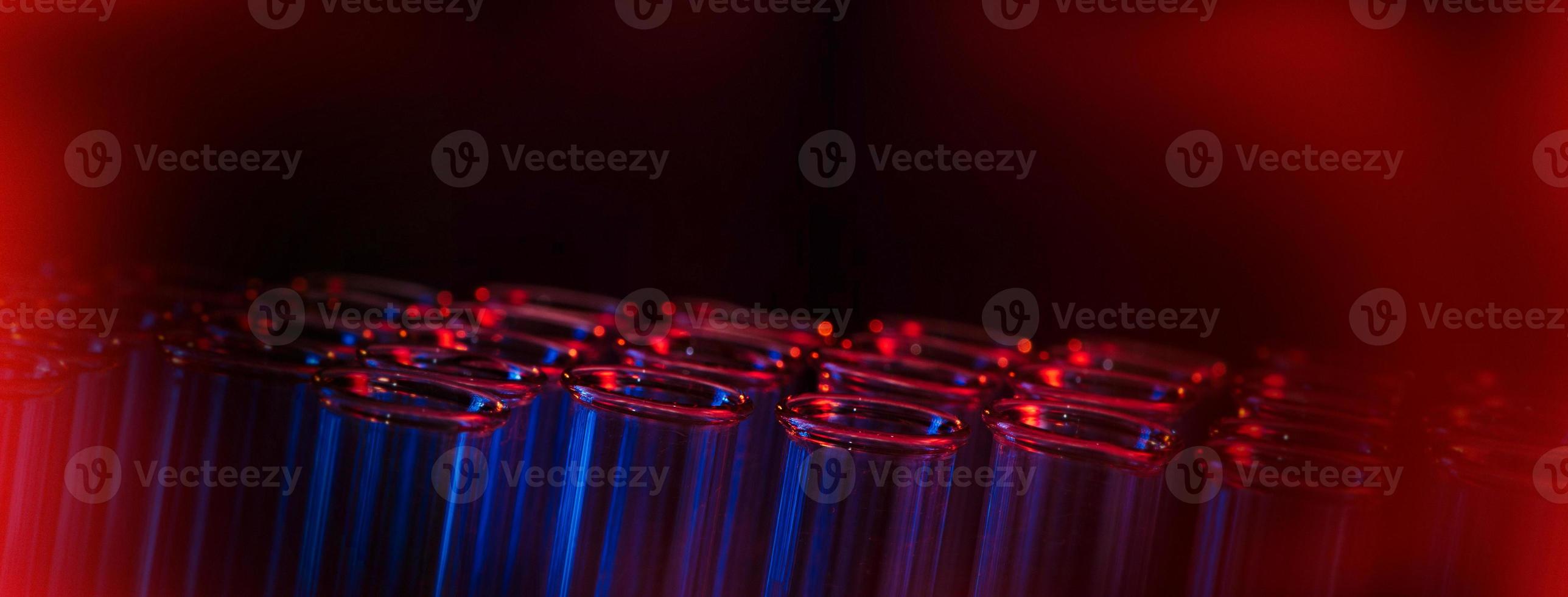 Test tube row. Concept of medical or science laboratory, liquid drop droplet with dropper in blue red tone background, close up, micro photography picture. photo