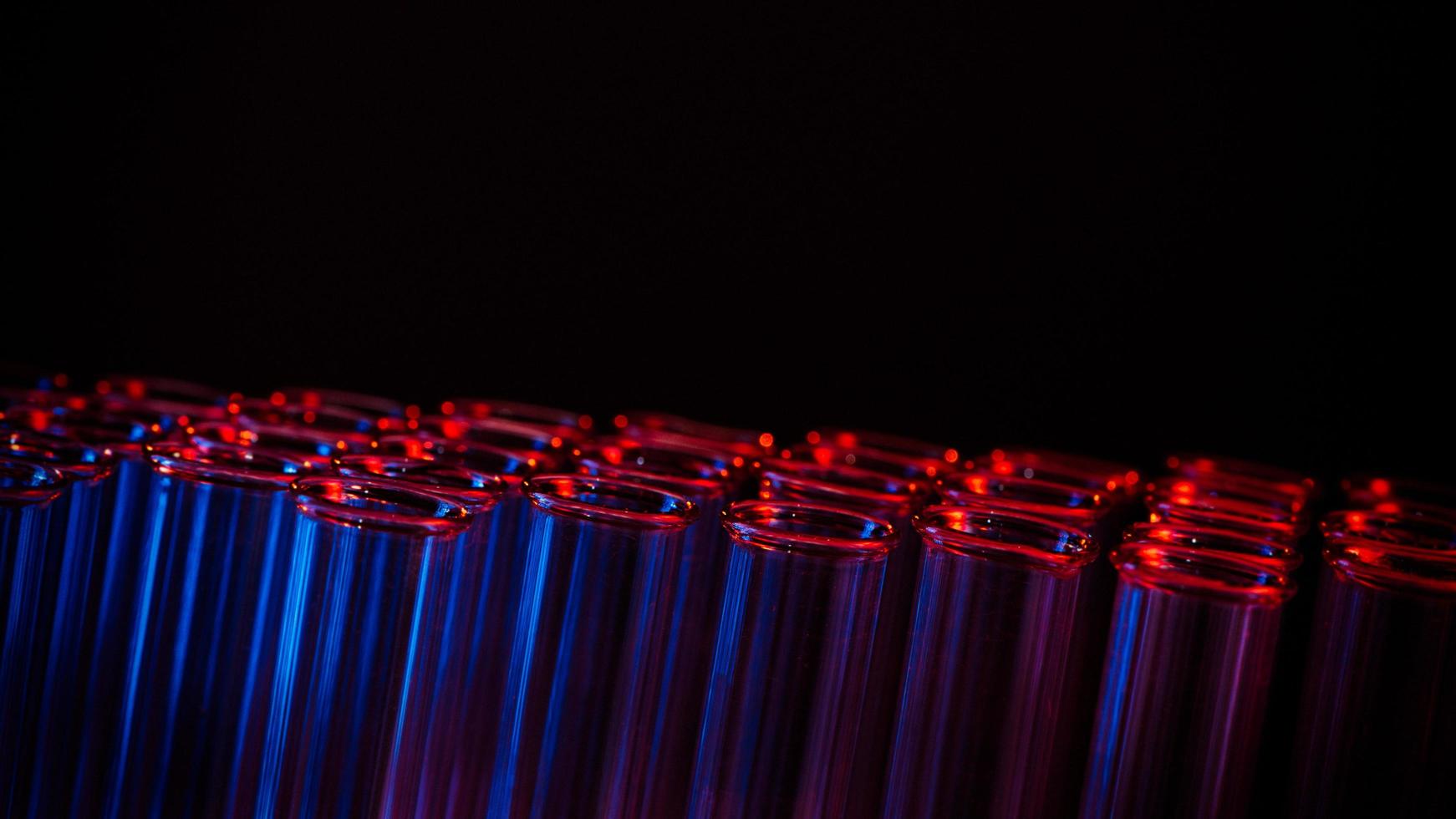 Test tube row. Concept of medical or science laboratory, liquid drop droplet with dropper in blue red tone background, close up, macro photography picture. photo