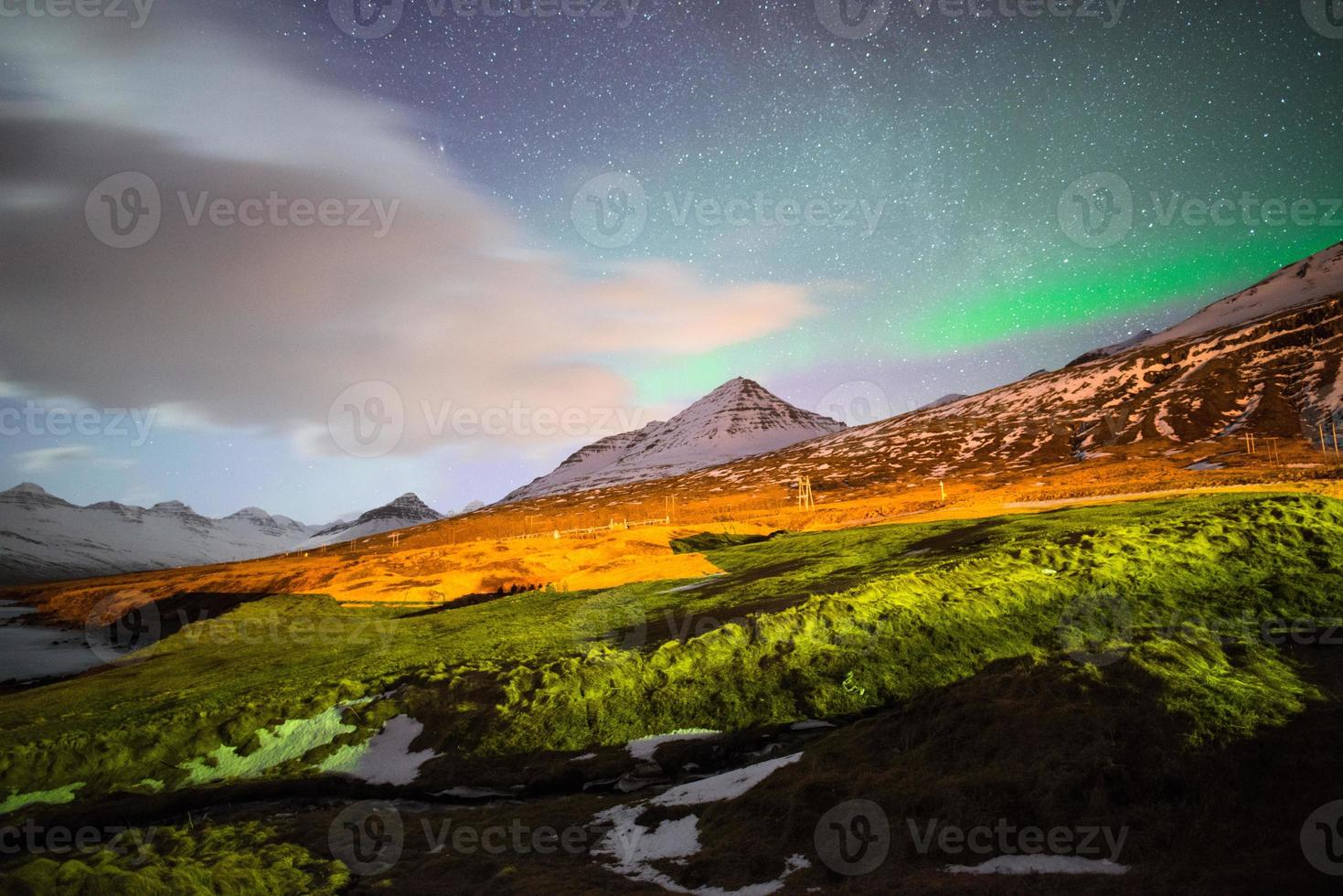 The Aurora Borealis over the mountains range of Stodvarfjordur town in East Iceland. photo