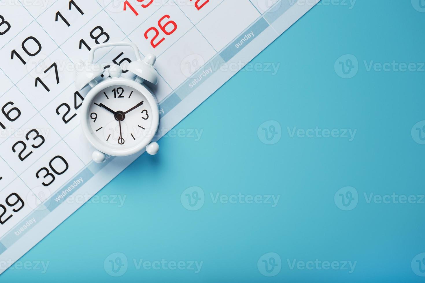 Annual calendar with a white alarm clock on a blue background photo