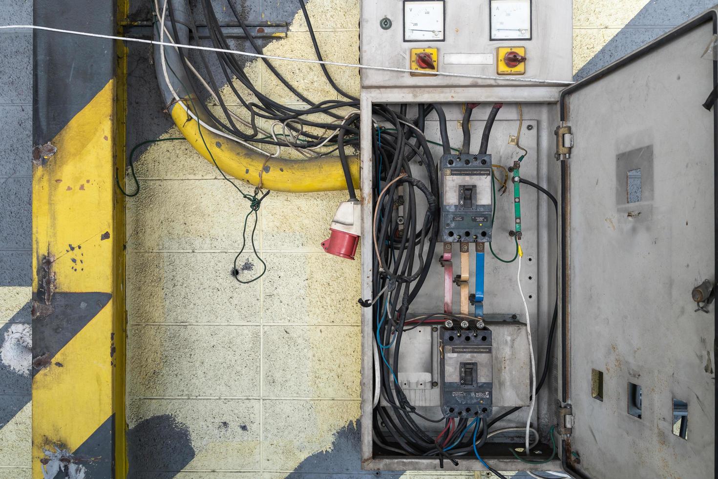 Dangerous three-phase 220v electric breaker steel cabinet. The wiring is not neat, the power connection box is attached to the external cement wall. photo