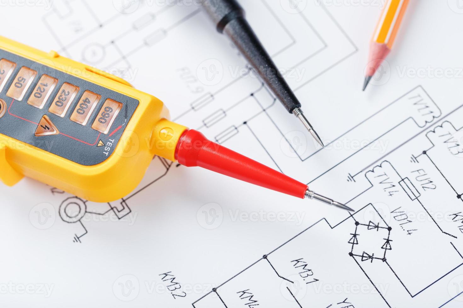 The two-pole voltage indicator lies on the electrical drawing. photo