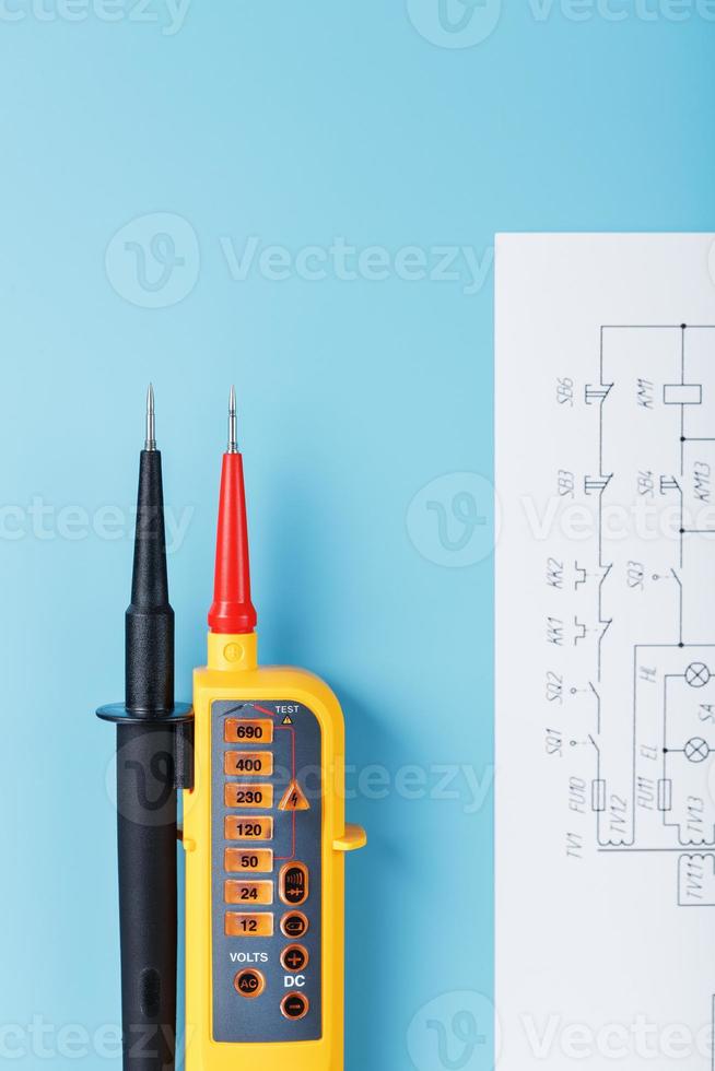 Yellow voltage indicator with an electrical diagram on a blue background. photo