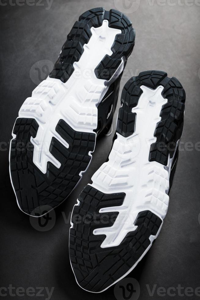 The black and white sole of trendy sports sneakers is a close-up in full screen. photo